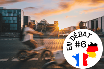 Zwei Personen auf dem Fahrrad in der Abendsonne. Im Hintergrund ist der Bundestag zu sehen.